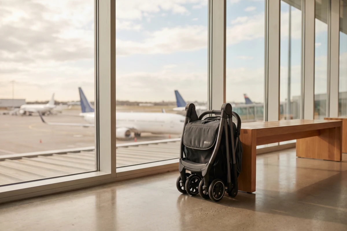공항 탑승 게이트 창가에 세워 둔 접힌 휴대용 유모차